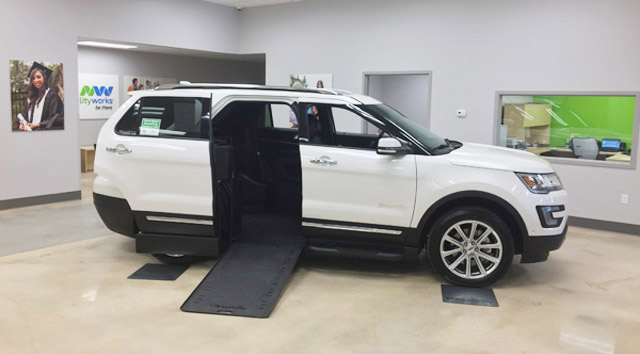 interior of MobilityWorks Bear showroom with white side-entry wheelchair van with ramp deployed