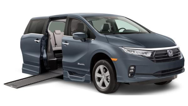 A blue/gray 2023 Honda Odyssey with BraunAbility side entry conversion, with the ramp deployed
