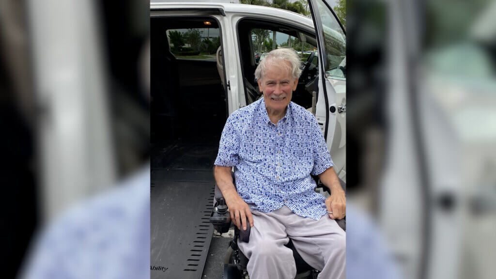 US Navy veteran John Bollinger poses next to his new accessible vehicle.