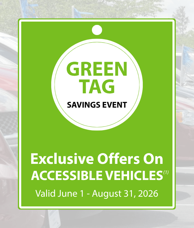 Bright green tag sign reading GREEN TAG SAVINGS EVENT: Exclusive Offers On ACCESSIBLE VEHICLES. Valid June 1 - August 31, 2026 displayed in front of parked vehicles.