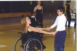 Mary demonstrating physically integrated partnering in a school auditorium demonstration