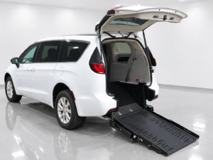 White minivan with rear hatch open, featuring a deployed wheelchair ramp for accessibility in a clean indoor setting—showcased as part of the latest MobilityWorks promotions.