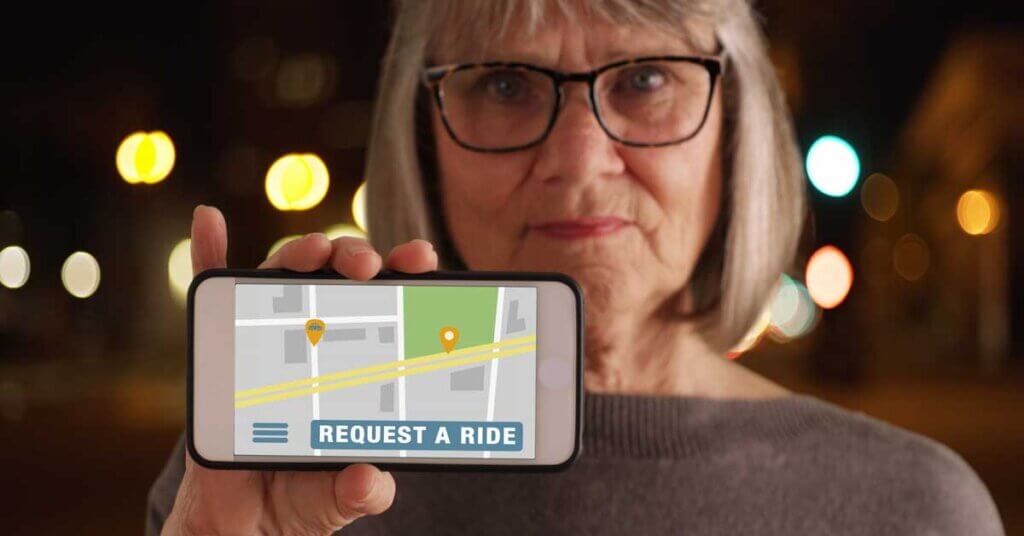 Woman showing phone screen to camera with rideshare application open