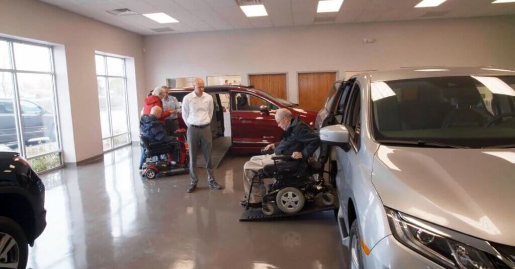 Gentleman in wheelchair exits accessible van next to Certified Mobility Consultant