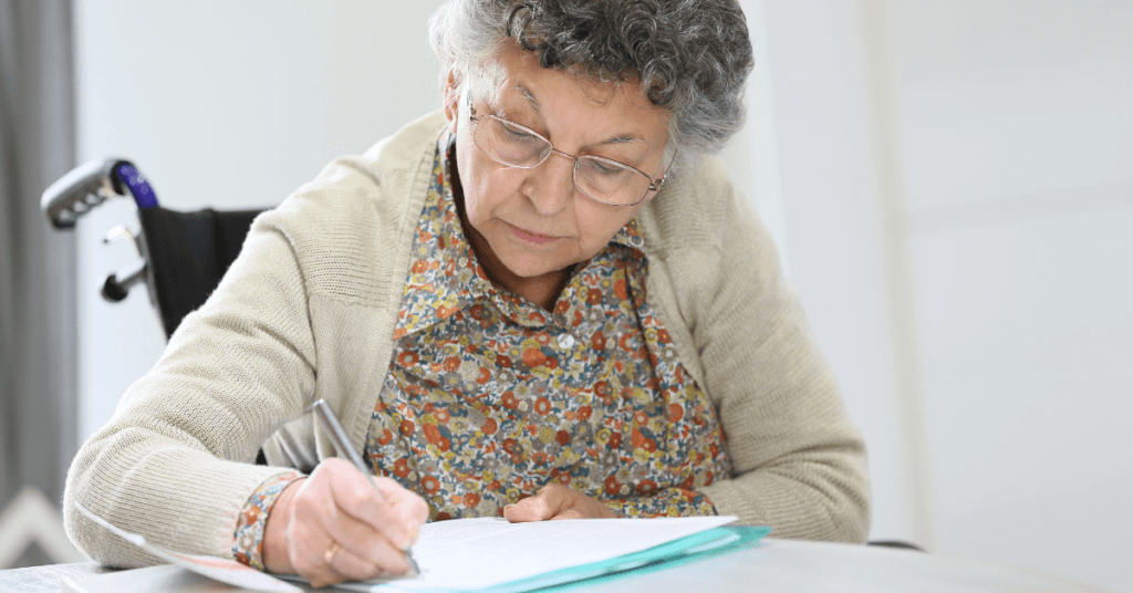 Elderly woman in wheelchair filling out medical form