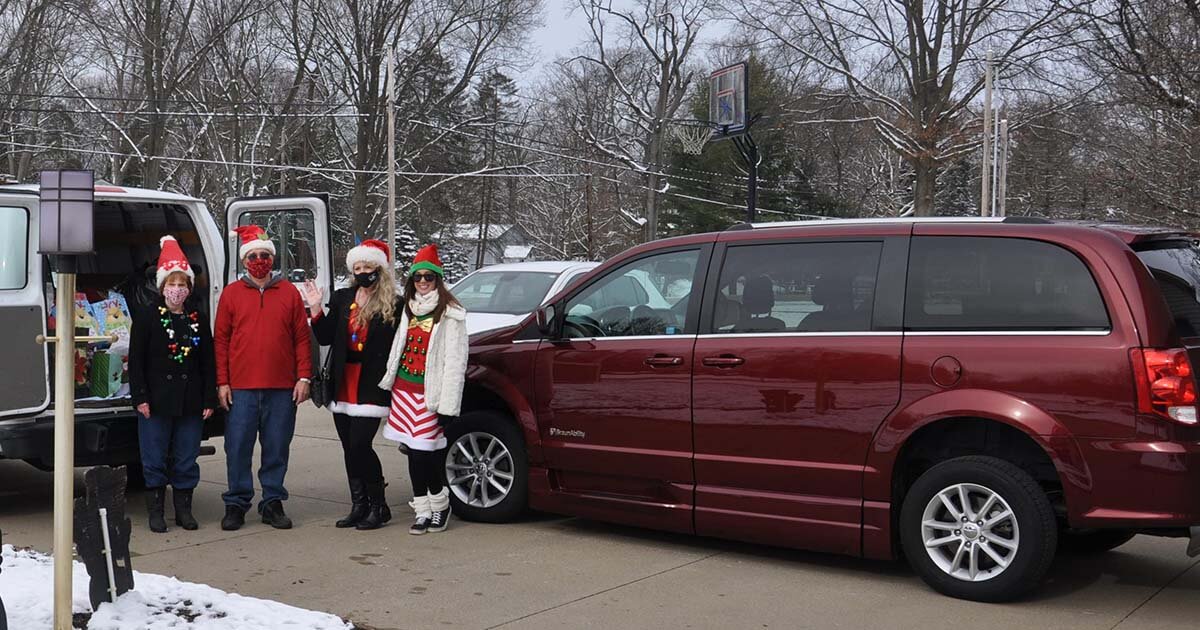 La familia se encuentra junto a la camioneta MobilityWorks lista para repartir regalos.