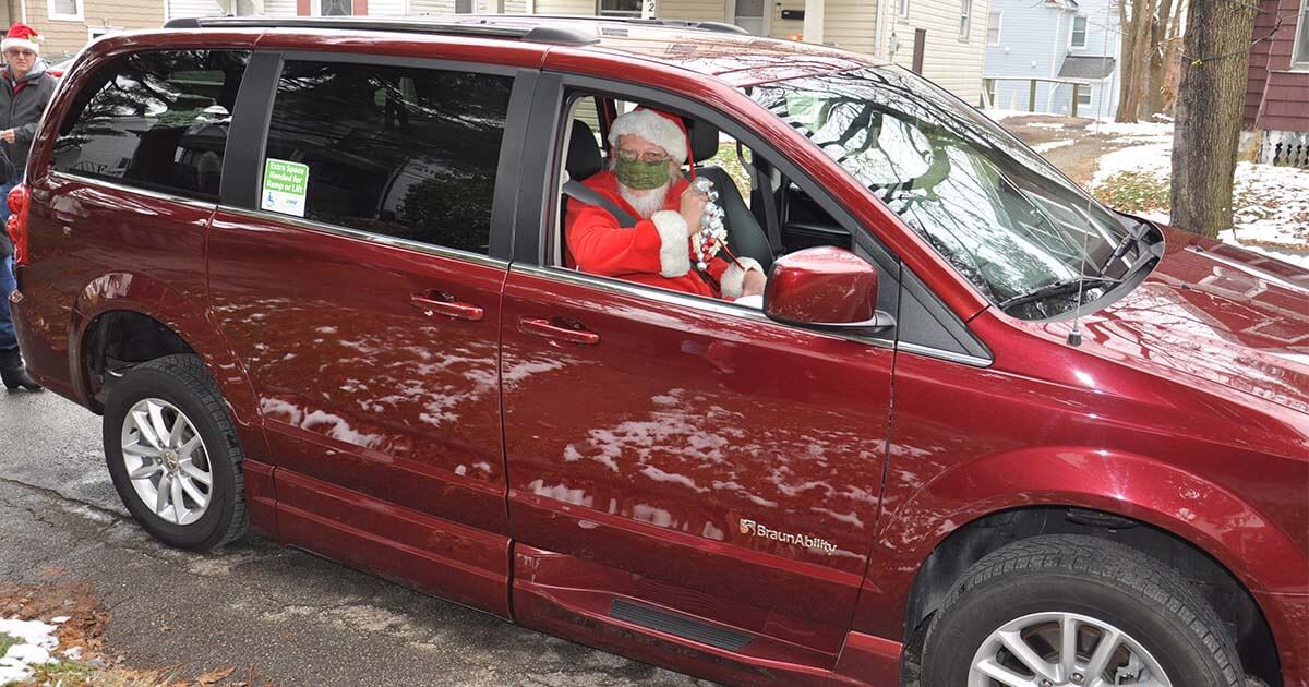 Santa Claus rides in the front seat of MobilityWorks van.