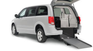 Ramp attached to a gray wheelchair van with rear door open. 