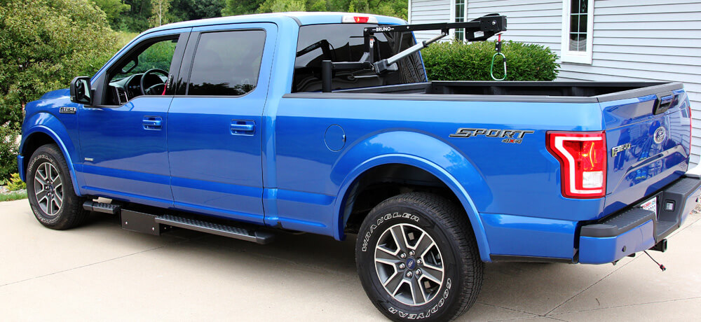 Blue pickup truck with a Bruno Out-Rider wheelchair lift in truck bed