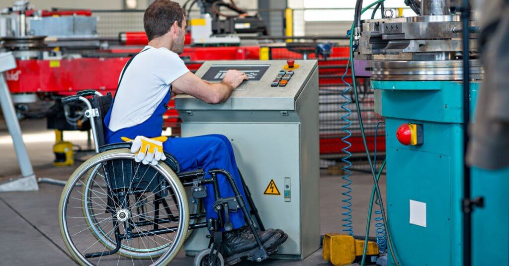 man in wheelchair working in manufacturing shop