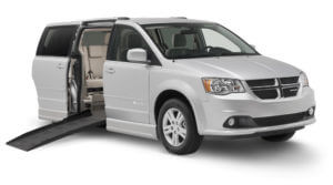 Gray Dodge wheelchair van with braunability logo and the inside of the rear seats exposed. 