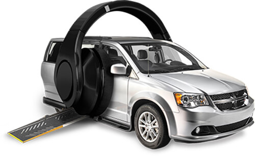 Furgoneta de movilidad plateada brillante con rampa para sillas de ruedas y enormes auriculares de oreja negra que rodean ambos lados del vehículo