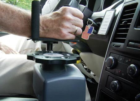 person using electronic hand controls on a vehicle