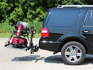 SUV with wheelchair lift installed on back holding red scooter