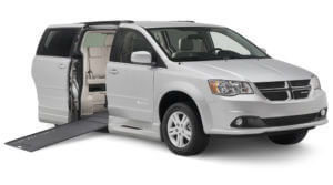 Small image of gray Dodge wheelchair van with slightly elevated ramp and braunability logo on passenger side door 