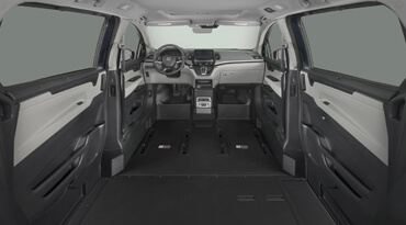 Vista interior del vehículo accesible con rampa en el piso y asientos delanteros retirados