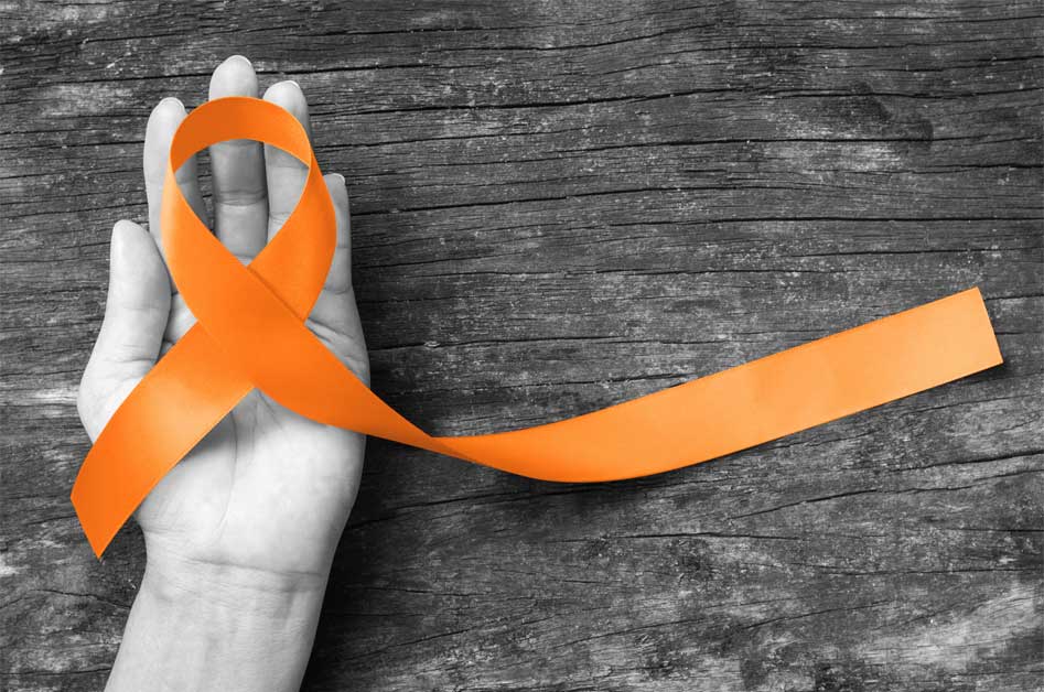 hand holding an orange ribbon for MS awareness