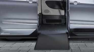 Side entry manual ramp on a shining blue wheelchair van 