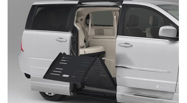 Manual ramp folding back into a white wheelchair van 
