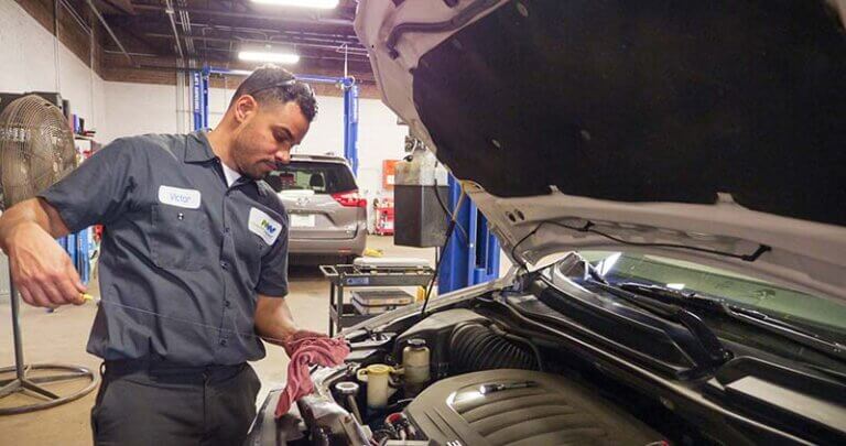 Service Tech checking oil of vehicle