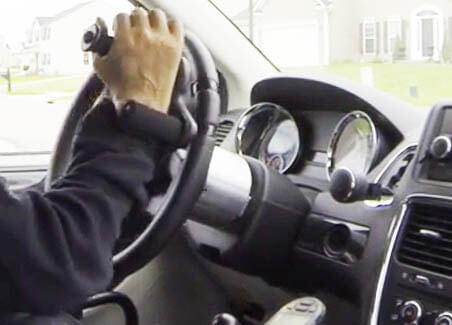 A person gripping a spinner knob during a daytime drive