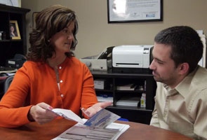 Female consultant helping man with wheelchair van financing in an office 